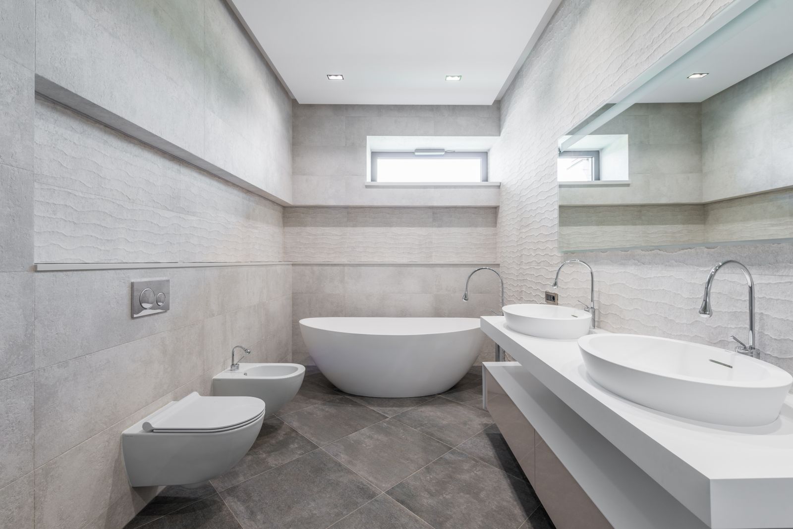 Salle de bain contemporaine avec carrelage gris au sol et aux murs, photo d’illustration
